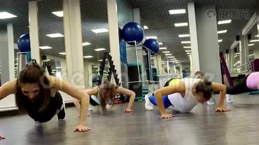 漂亮的年轻女性在锻炼时做俯卧撑视频