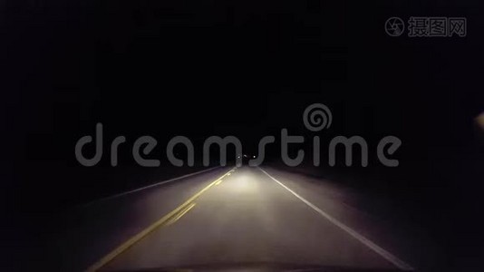 夜间驾驶农村公路进入城市。 从乡村进入城市灯光的司机视角视频