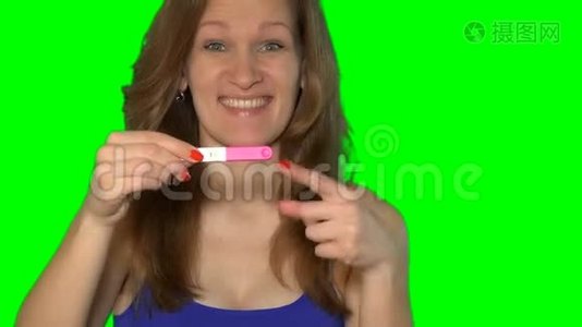 兴奋的女人用两条条纹显示怀孕测试，看镜头视频