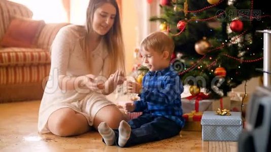 圣诞早晨，小男孩和妈妈一起在客厅里扔彩纸，开心地笑着视频