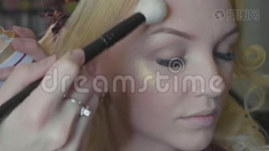 年轻的化妆师在模特`脸上闪耀。视频