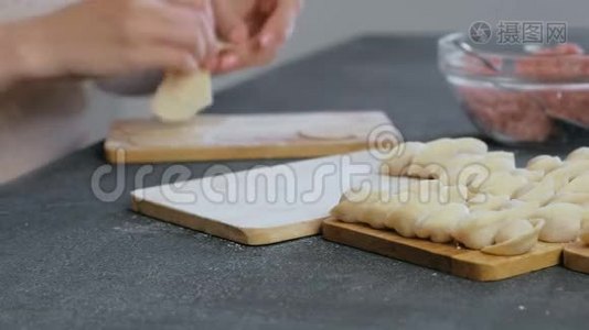 女人用肉馅包饺子，特写的手。 侧视。视频