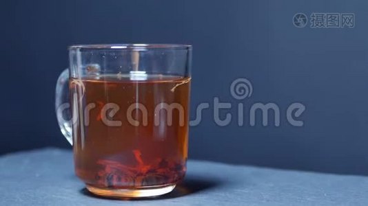 热茶倒入玻璃杯中.. 透明玻璃茶壶和茶杯。 慢动作视频