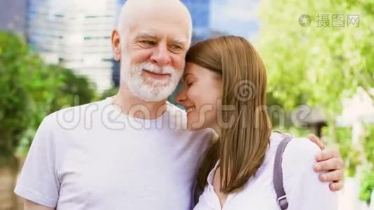 年长的父亲和他的小女儿站在街上。 快乐的家庭一起享受视频
