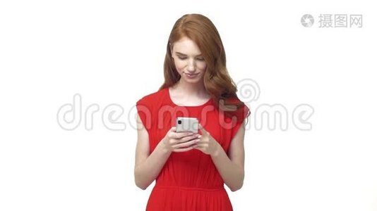 年轻积极的美女在智能手机上聊天和发短信，微笑着对着灰色隔离的镜头视频