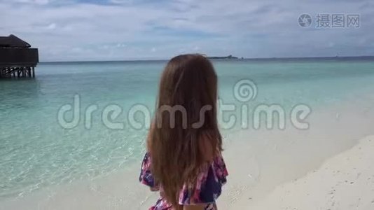 快乐的女人在马尔代夫的海边散步、微笑和欢乐视频
