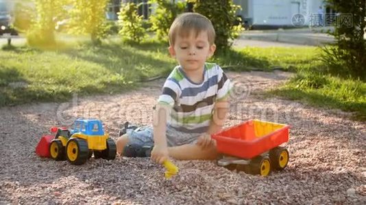 4k小男孩在公园操场上玩拖拉机和拖车的视频视频
