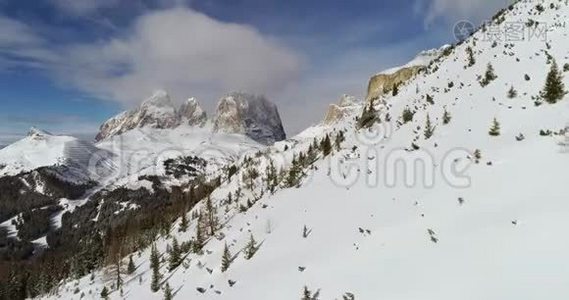 从空中飞过白雪皑皑的山谷，在Pordoi山口有森林。 晴天，天空多云。 冬季白云视频