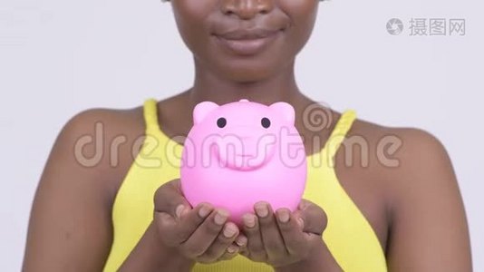 快乐的非洲年轻女子微笑着拿着储蓄罐视频