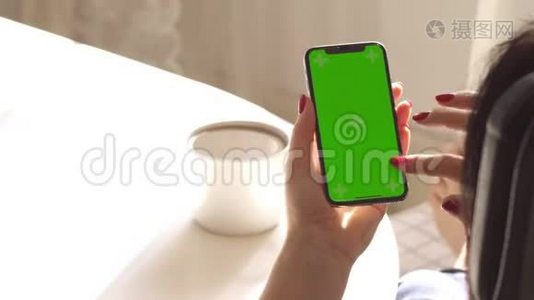 女性手握智能手机。 绿色屏幕。 赫罗莫基。 这个女人有一个红色的指甲。视频