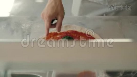 餐厅的厨师准备了一份披萨，并用番茄拉和罗勒装饰视频