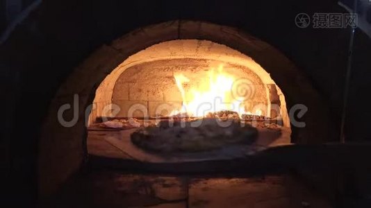铁锹把比萨饼放进木炉里，火焰燃烧得很快视频