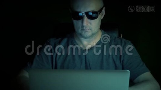 男人坐着笔记本电脑和上网。 计算机上的人编码。 黑暗的夜晚。 低调。视频