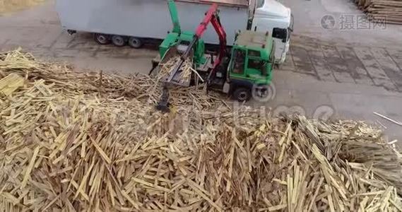 一辆装有机械手的卡车将木柴装入碎纸机中，用作木柴。 一辆装有生物燃料的卡车。 生物燃料视频
