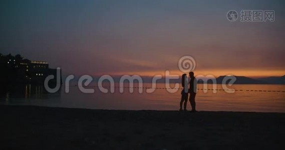 夕阳下的爱情故事。 在岸边站着的时候，男人和女人彼此温柔地接吻视频