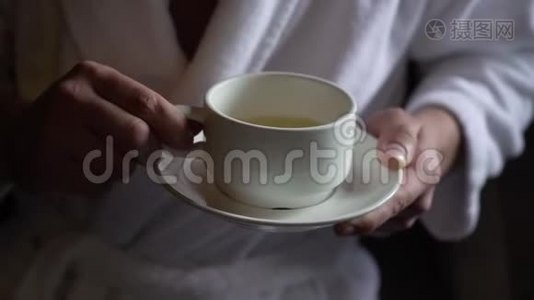 年轻人早上从杯子里喝茶。 家庭早餐视频