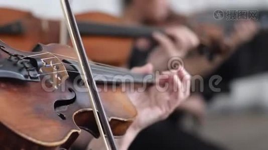 交响乐团女声在室内交响乐团的模糊背景下演奏小提琴视频