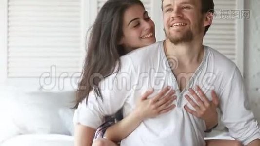 年轻夫妇坐在床上，美女拥抱男人视频