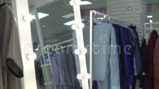 在一家服装店里，一个年轻的女人在镜子前外套视频