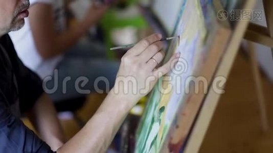 艺术家画油漆刷的图片.. 男性艺术家手中的画笔。 艺术观念。 特写绘画画面视频