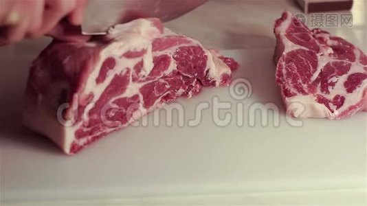 厨师把新鲜猪肉切成牛排。视频