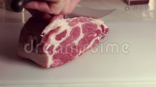 厨师把新鲜猪肉切成牛排。视频