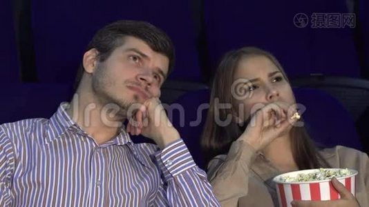 一对可爱的夫妇在电影院看电影时感到无聊视频