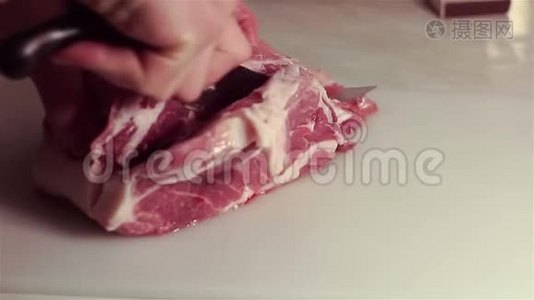 厨师把新鲜猪肉切成牛排。视频