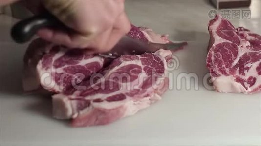 厨师把新鲜猪肉切成牛排。视频