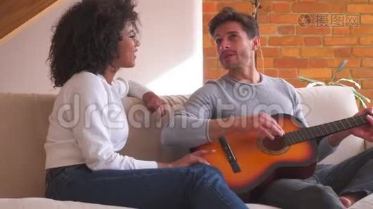夫妻俩在家里沙发上弹吉他唱歌视频