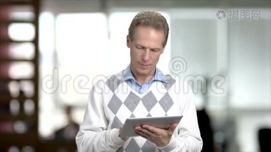 成熟的男人在电脑平板电脑上上网。视频