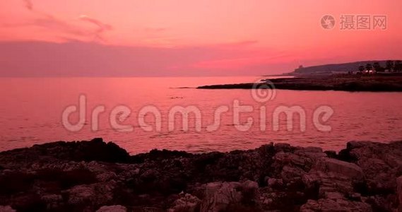 热带加勒比海海滩海，日落时有金色的沙子和岩石，天空五彩缤纷，海洋运动缓慢，度假，放松和视频