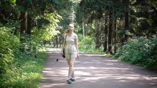 穿着短裤和t恤的苗条女子走上了公园的小路视频