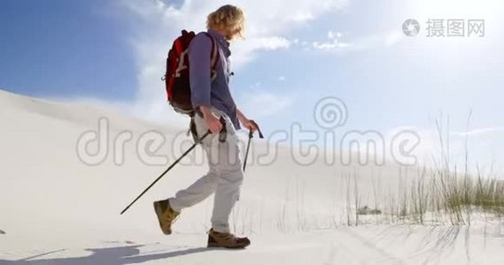 带着登山杆在沙漠中行走的人视频