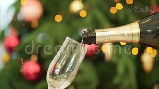 特写香槟倒入酒杯，背景上的圣诞树。 将香槟倒入玻璃的特写镜头视频