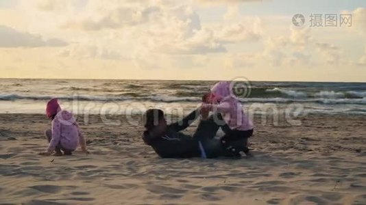 日落时分，妈妈和两个女儿在沙滩上玩耍视频
