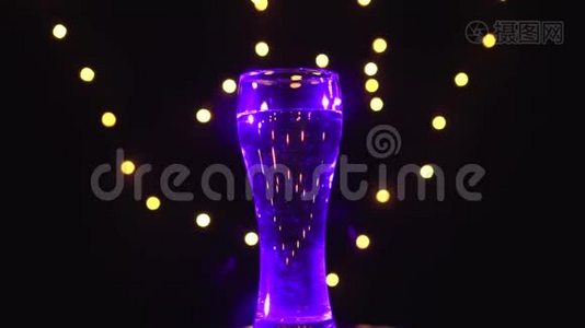 紫外线下的一杯水在旋转。 紫外线鸡尾酒。 酒吧概念视频