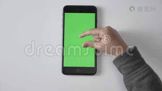 孩子们`手在智能手机上做捏来缩放手势，绿色屏幕，色度概念，顶拍60fps视频