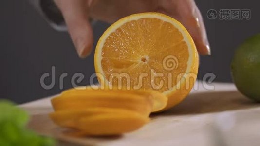 一个女人在餐桌上用刀切橘子。做橙汁的女人。视频