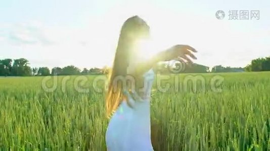 美丽的女孩在日落时在麦田里跑着玩。 自由，健康，幸福的理念.. 快乐的年轻女子视频