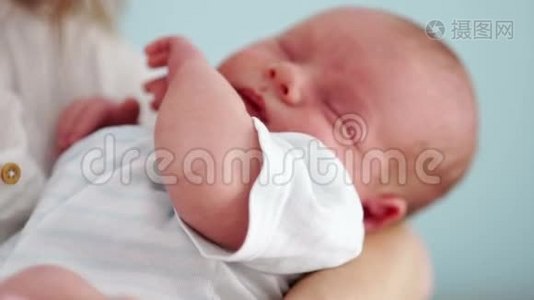新生儿的肖像。 他和他的母亲睡在怀里，在睡梦中移动手柄。 儿童节`..视频