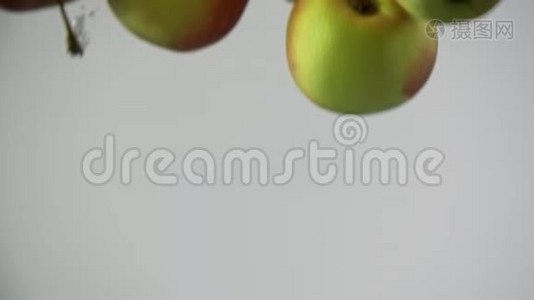新鲜水果苹果红黄落在水中，随着气泡旋转视频