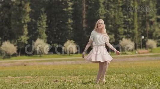 一个快乐的年轻俄罗斯女孩正在城市公园里奔跑。视频