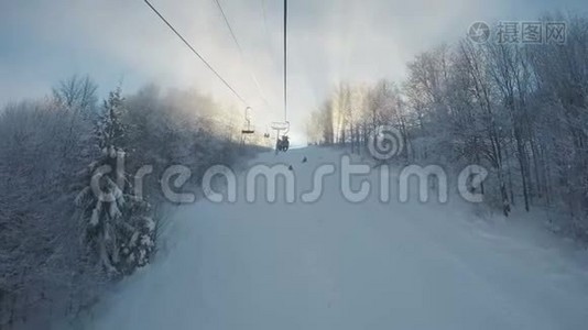 从滑雪缆车到美丽的雪坡，路旁有蓬松的白色树木视频