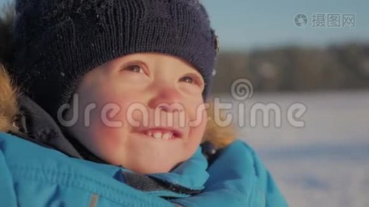 冬天特写户外可爱梦幻的小男孩肖像，快乐的小男孩在雪地里玩耍，户外。视频