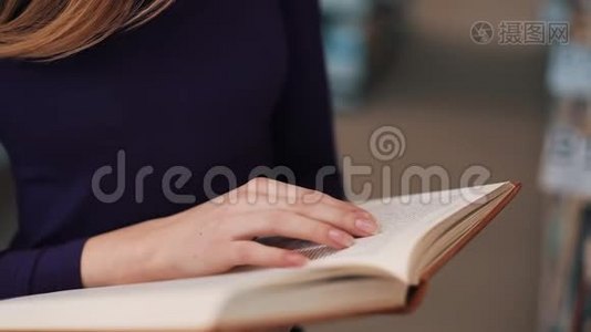 女孩把手指放在图书馆看书的书页上视频