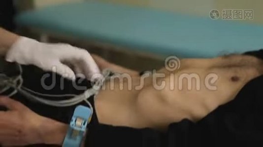 医院护士在病人四肢上固定电极，用于心脏学测试，设备视频