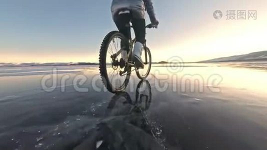 轮胎的视图。 拍摄60fps动作摄像头。 女人在冰上骑自行车。 冰的贝加尔湖。 轮胎视频
