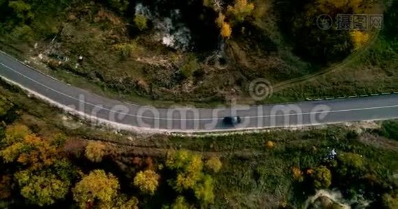 在乡间道路上驾驶汽车穿过森林的鸟瞰图。 美丽的风景，空旷的乡村道路，红色的树木视频