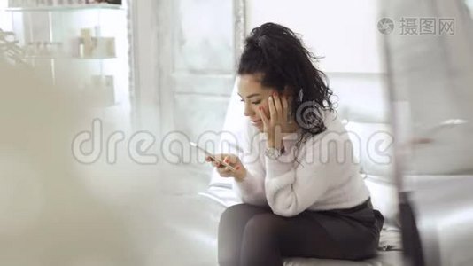 女士使用智能手机，同时等待美容诊所的手续邀请视频